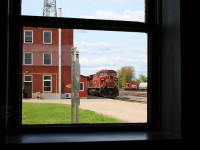 Through the window of the old Smiths Falls VIA station, CP 9675-232 awaits a crew change while CP 8203 works the yard.