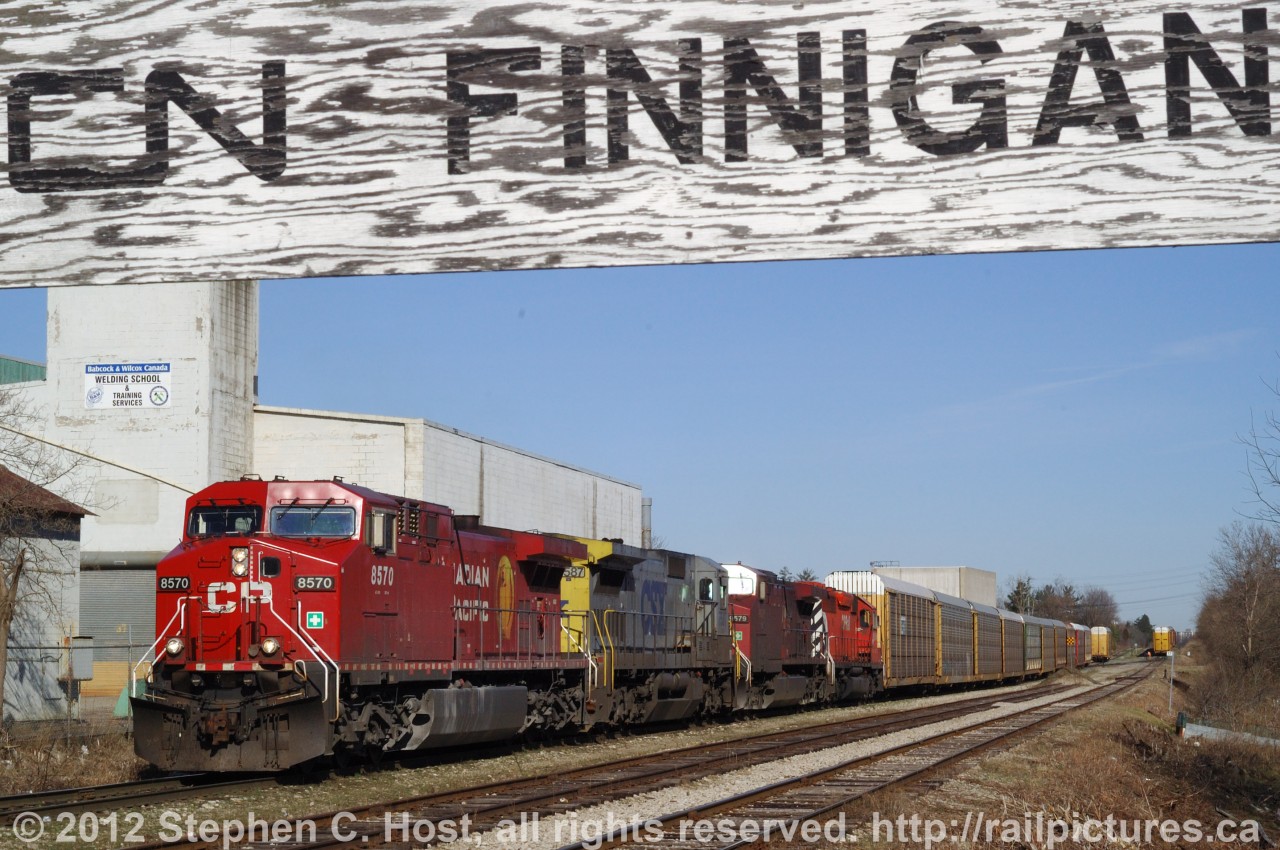 CP train 138 (with CSXT 7587) is making a lift of some fresh Toyotas on the CP Waterloo subdivision. The CN sign may confuse - but the track on the right is the CN Fergus spur and "CN Finnegan" indicates essentialy the end of the Fergus spur and switch with CP. This CN track runs about 16 miles to Guelph, Ontario and about 2 miles is/was leased from CN for outbound Toyota storage, while the rest of the track is the GEXR Fergus spur and is used to service the plant in the background, Babcock and Wilcox, for occasional shipments. This scene is no longer possible as a road overpass and railway lowering has occured, the sign and much of this track has been removed or relocated, and trains now lift/setoff at Wolverton yard.