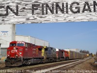 CP train 138 (with CSXT 7587) is making a lift of some fresh Toyotas on the CP Waterloo subdivision. The CN sign may confuse - but the track on the right is the CN Fergus spur and "CN Finnegan" indicates essentialy the end of the Fergus spur and switch with CP. This CN track runs about 16 miles to Guelph, Ontario and about 2 miles is/was leased from CN for outbound Toyota storage, while the rest of the track is the GEXR Fergus spur and is used to service the plant in the background, Babcock and Wilcox, for occasional shipments. This scene is no longer possible as a road overpass and railway lowering has occured, the sign and much of this track has been removed or relocated, and trains now lift/setoff at Wolverton yard.