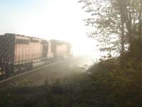 A sunny, bright September 21, 2006 early morning and a dense fog/mist rises from Mud Lake.  CP #152 with 5949 & 5696 heads into the abyss onto Mud Lake Trestle , mp 27.4 of the Belleville Sub