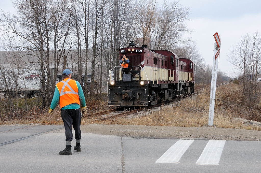 Before the new yard for Polymer Distribution Inc. (PDI) was built just west of Imperial Road in Guelph, the "North Industrial Spur" was only used as far MBI Smurfit (building to the left) and this crossing seen little use. However on occasion PDI would have overflow traffic that couldn't be handled at their main yard (located off Victoria Road) and would be spotted near the end of track for transload. On November 20, 2009 the brakeman on the OSR crew protected the rarely used Imperial Road crossing, as he radios to the enginer to move his pair of MLW RS-23's forward so they could grab the one hopper that had been spotted.
