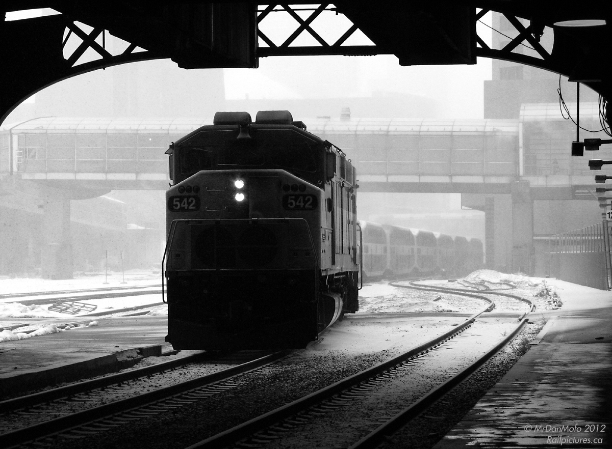 The weather outside is frightful, but on the train it's so delightful. GO F59PH 542 comes out of the falling snow under the train shed at Union Station, with Lakeshore East train 920 in tow for passengers waiting by Track 2. Let it snow, let it snow, let it snow.