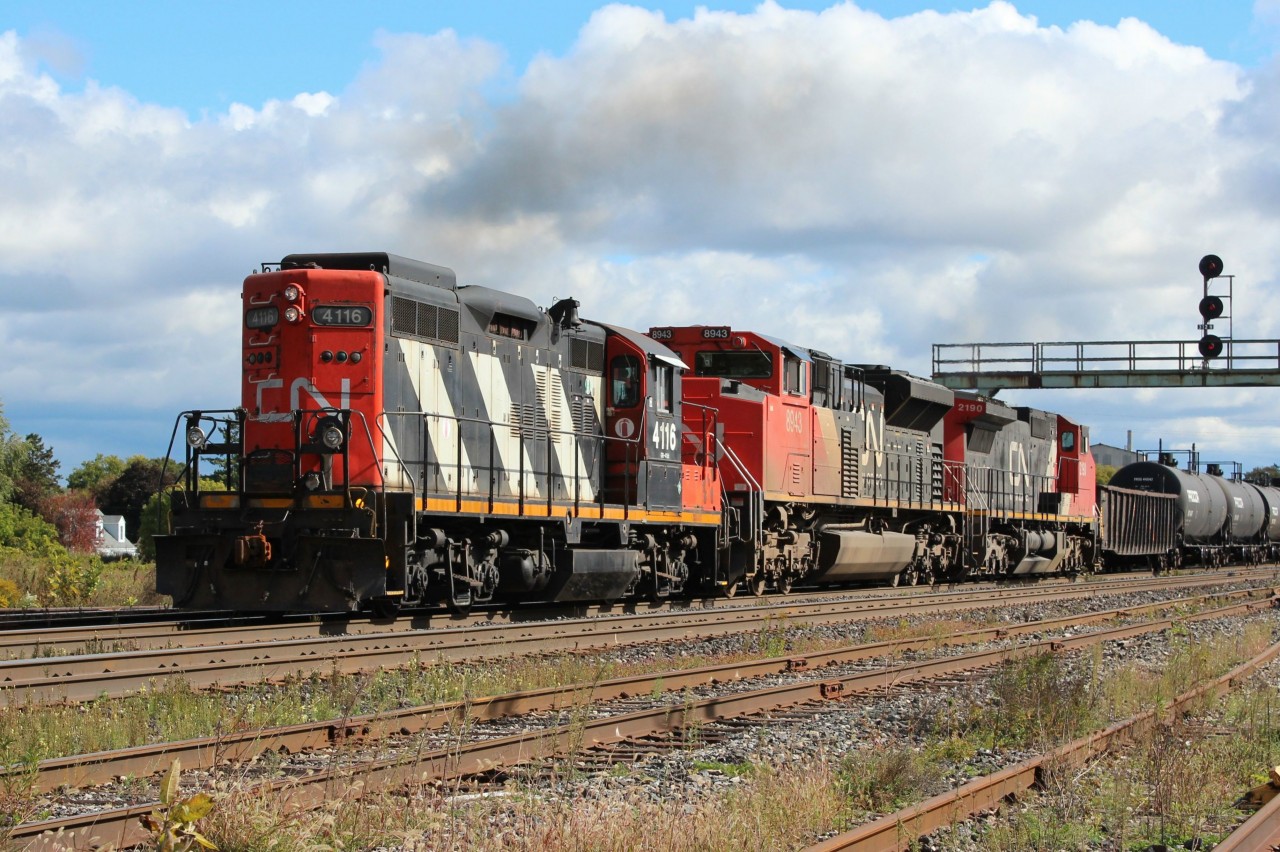 GP9 RM no. 4116 is almost dwarfed by her newer and bigger sisters as they pull into the yard at Paris Jct. It seems that 4116, the yard engine from nearby Brantford was subbed in to replace an ailing road unit on the train which was cut off in Brantford. After helping to get  the train to Paris, 4116 will be cut off to return to Brantford. The train is slated to leave about a third of its consist in Paris and so will continue on  without its `helper".