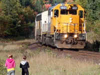 With only one more day of scheduled Northlander train service 1801 is greeted at Utterson by several folks inculding two guys from Germany and these two kids taking the back way home from school.