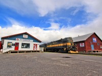 Just like the days of the old: An Alco RS11 splits the property of H.H. Goode and Sons Feed and Farm Supplies in two as it departs Uxbridge Station for a Sunday excursion.