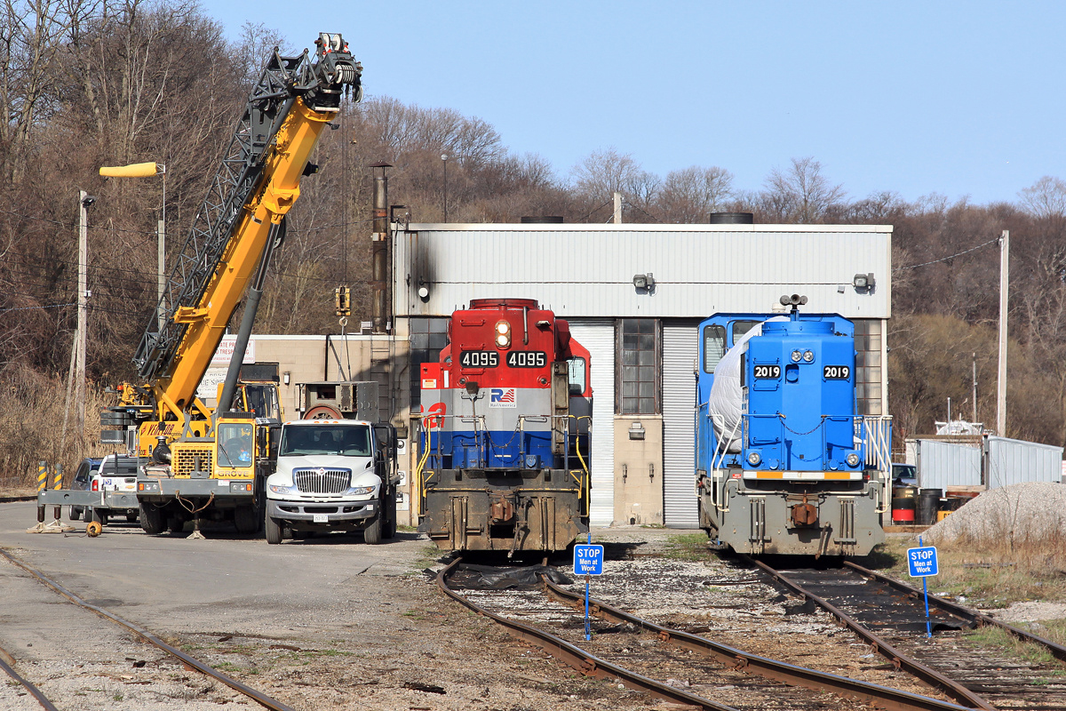 RLK 4095 and CEFX 2019 sit on the shop tracks as a crane offloads some machinery from a truck.