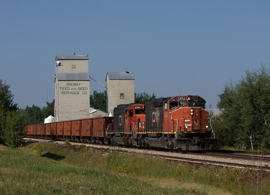 2 SD40-2's pull an OCS ballast train through the small town of Onoway