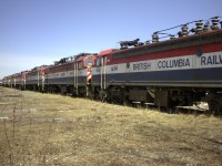 A congo line of retired BC Rail electric locomotives sits in Prince George yard on a cool but sunny May afternoon.