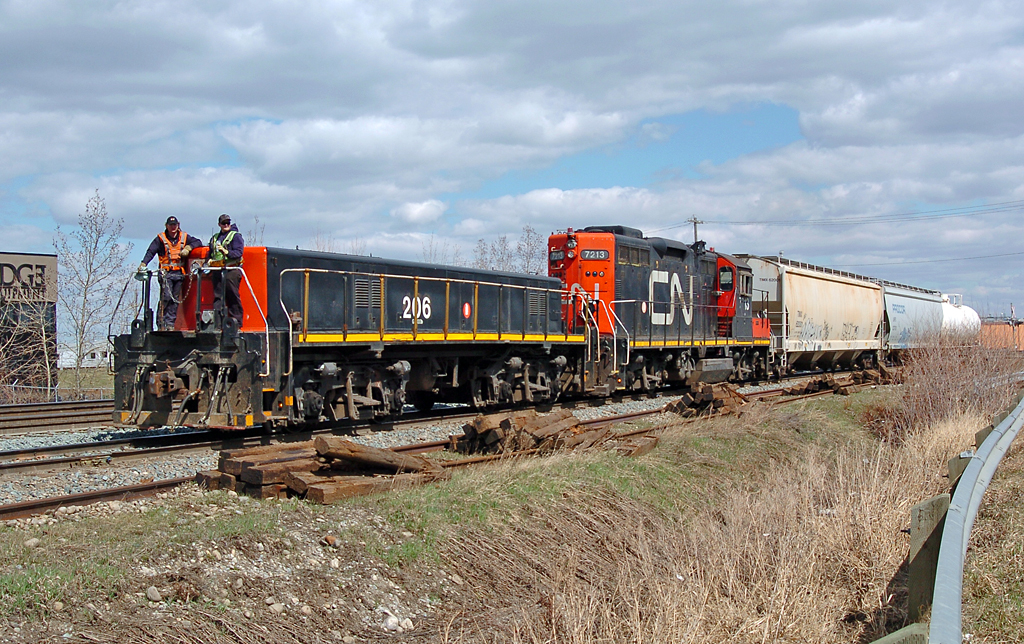 After switching the "Bonaventure" industrial spur situated between Walker and Bissel yards, the crew takes the three-car train back to Bissel while riding on the front of GMD/CN YBU-4 number 206, with the actual power coming from GMD/CN GP9RM number 7213.