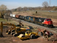 CN 2535 and CSXT 4821 power 338 past the heavy machinery that will be used to grade the new yard lead and third main track.