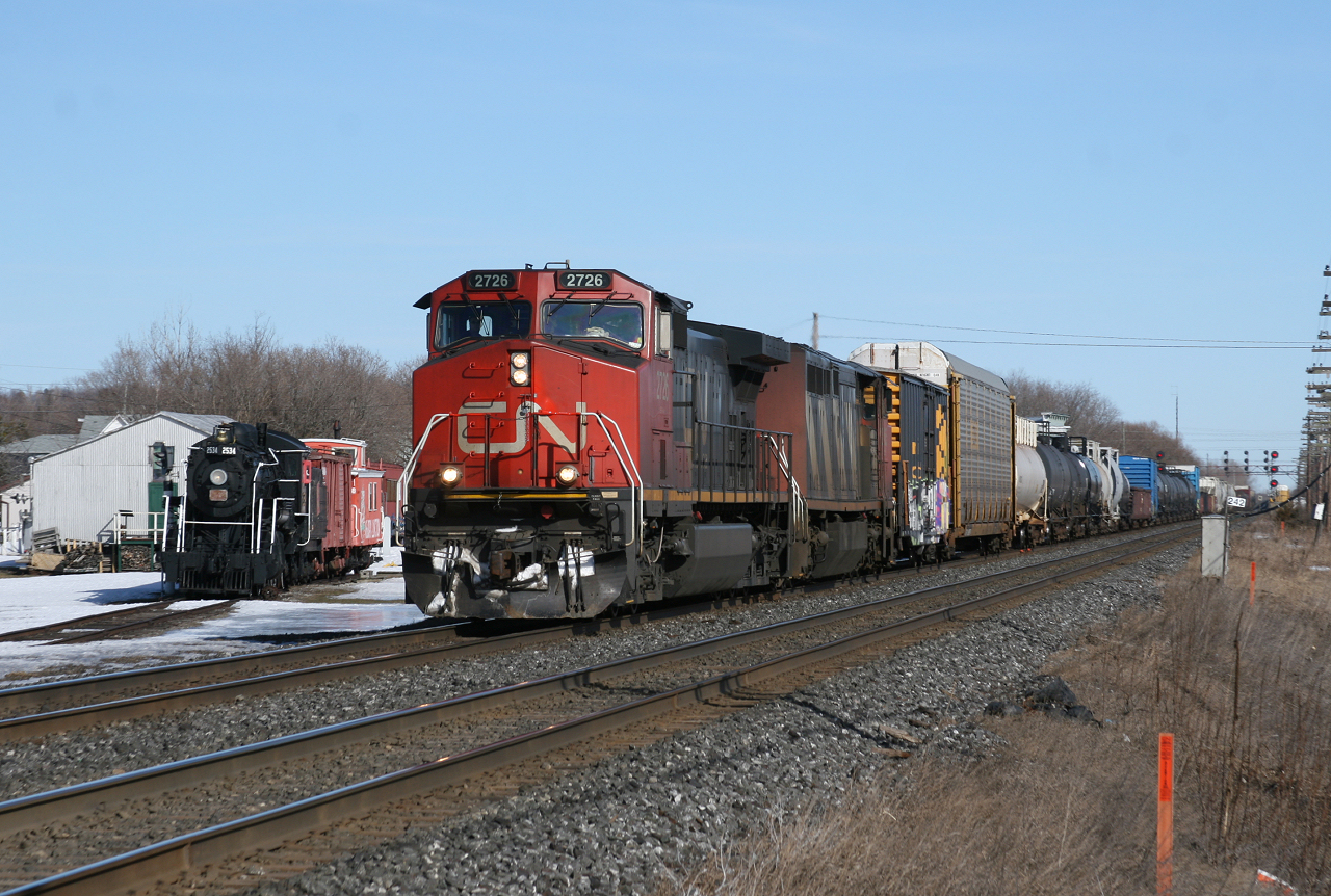 CN 369 screams by the Memory Jct Museum as a CN Ten Wheeler looks on.  369's trip is about to get a whole lot longer, CN 121 has just stalled at Newtonville and 369 has been volunteered to give up his trailing unit.