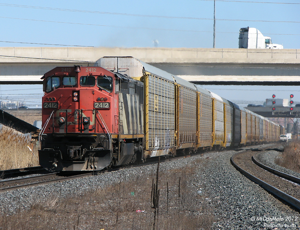 On a lazy afternoon, one-unit-wonder CN #275 with cowl-bodied Dash-8 2412 heads west with the usual solid racks of 275, past a hi-rail on the south track at Halwest before Bramalea GO Station.