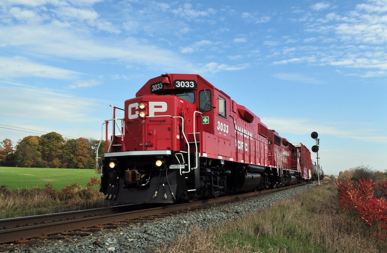 Heading Home: One five hundredth of a second is insufficient shutter speed to completely freeze frame the Cobourg Turn – CPR 3033 west – accelerating out of the M of W foreman's working limits at the west switch CPR Port Hope mile 144.0 Belleville Subdivision. Twenty nine year old GP38-2 3033, class DRS-20c, is assisted by twenty six year old sister 3114 ( a nice change from the constant GE parade). Over the years the Cobourg Turn (also known as the Trenton Turn) has been powered by a variety of interesting  power such as  MLW RS-3, RS-10, RS-18, even the TH&B geeps and .....(let us know what power you have seen....). Note the M of W foreman hi rail pickup truck in the Port Hope siding. October 22, 2012 image by S.Danko.