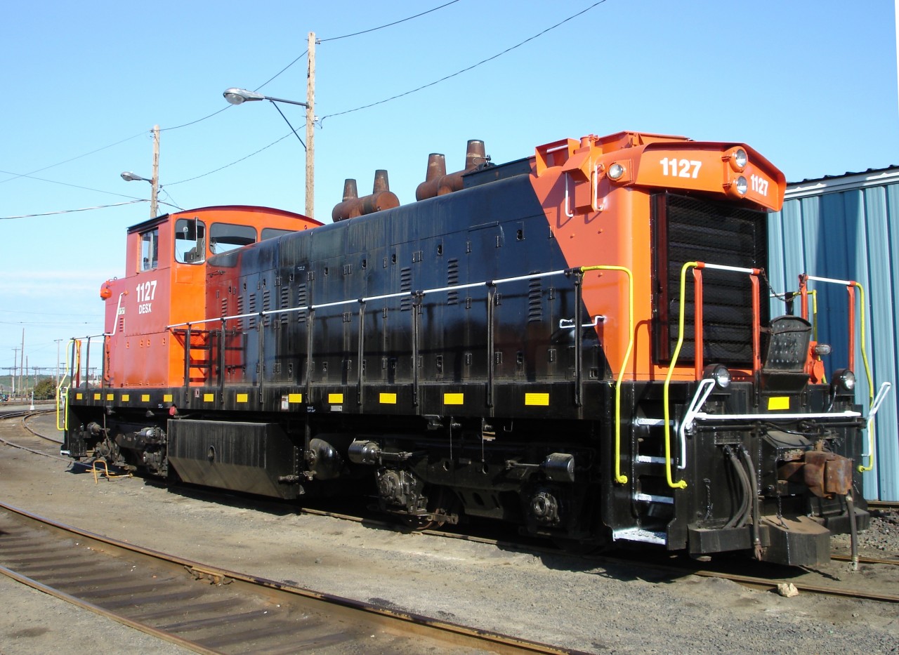 In a variation of recent CN paint schemes, freshly painted and recently delivered DESX 1127 (Diesel Electric Service I believe) with wheel chock in place, sits in the then I.N.C.O. (now VALE INCO) yard in Copper Cliff, ON waiting for something to do.  This ex-CN GMD-1 retains its classic dual snorkel spark arresting mufflers, however, the distinctive number boards have been covered over with sheet metal and white decals.