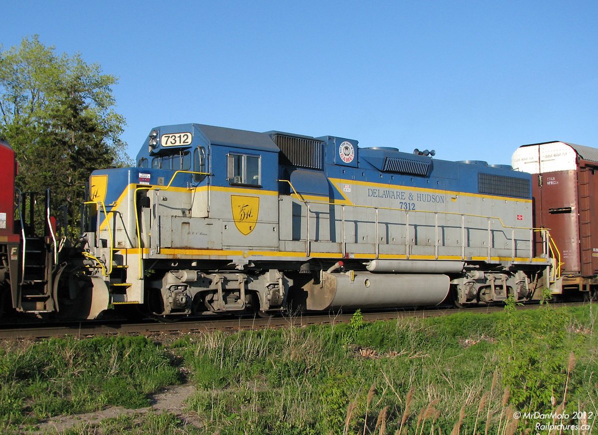 The odd time CP’s 7300 series GP38-2′s venture from their normal stomping grounds of the easter USA to Winnipeg, mostly for heavy repairs. Of those few units, three exist in the “fallen flag” Delaware & Hudson livery: 7303, 7304 and 7312. 7312, in the most accurate representation of the livery, had to head up to Weston shops in Winnipeg MB for front drawbar work. After getting skunked in a night chase north to Alliston with D&H 7312 in the lead, a chance for redemption came up. Enroute back to New York, D&H 7312 had come back down to Ontario for delivery home, trailing in 254′s consist. With last-minute word of the train departing Toronto and a work block closing part of the line for repairs, your humble narrator was able to make it down to Streetsville with time to spare, to catch CP #254 rolling through town with the very sharp looking D&H 7312 heading back home.
