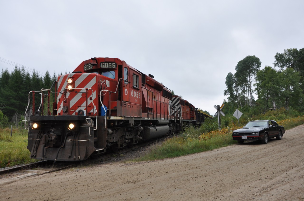 The last train to depart Chalk River is about to cross Leader Road around mile 2 of the North Bay sub. Note the sweet car in the forground.