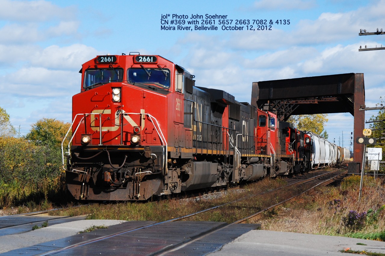 CN 2661 5659 & 2663 leading #369 has just lifted yard switchers 7082 & 4135 along with some loads at Belleville.  The train heads west at the Moira River, Belleville October 11, 2012