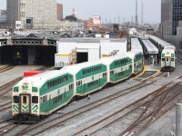 GO cab car 247 leads Barrie-bound train 801 out of the south end of Toronto's Union Station. To the right, 233 is waiting to depart with a Milton-line train on platform 27. Tracks 11 & 12 of the train shed are undergoing renovations as part of GO Transit's station modernization program. In the distance on the right, Scott St. interlocking tower can also be seen, along with the smokestacks of power generation plants off in the Portlands.