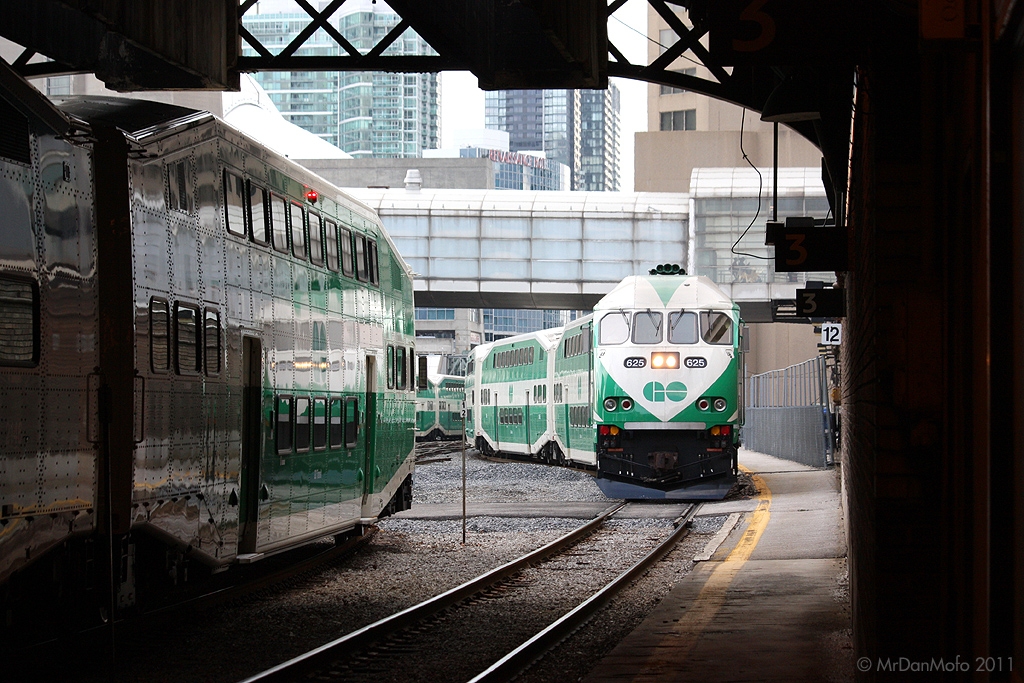 GO Transit MP40PH-3C 625 ducks under the train shed hauling the equipment for Georgetown-bound train 209, at the height of rush hour in Toronto. Even though their train and platform have not been officially announced yet on GO's electronic displays, 209's regular commuters crowd the platform behind the photographer waiting to get an earlybird seat.