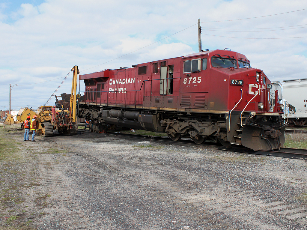 The locomotive equivalent of putting a spare tire on a car because of a flat. In this case it requires a lot more people and some heavy equipment. 8725 was set off the prior day because of overheating bearings on the #5 traction motor. Here the defective axle and traction motor are being removed and a dummy axle (no traction motor) will be installed with the help of Hulcher. Afterwards this unit will head to Toronto to get a new wheel set installed.