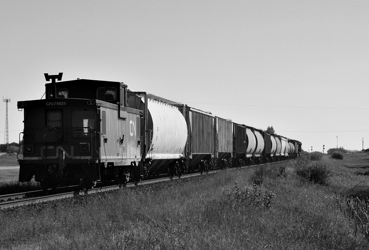 CN 560 crew requires to do along back movement at PCS Allan which requires a CN caboose or what they are sometimes referred to by the crews a riding platform on the rear as it passes through the small town of Clavet Saskatchewan.