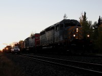 CN 480 passes through Wagaming at dusk. The NOD Surfacing gang is in the ditch, which will follow the train to Auden.