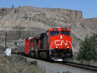 CN 302 highballs out of Ashcroft under the towering sandstone cliffs that briefly forces the CN over to the CP side of the Thompson River