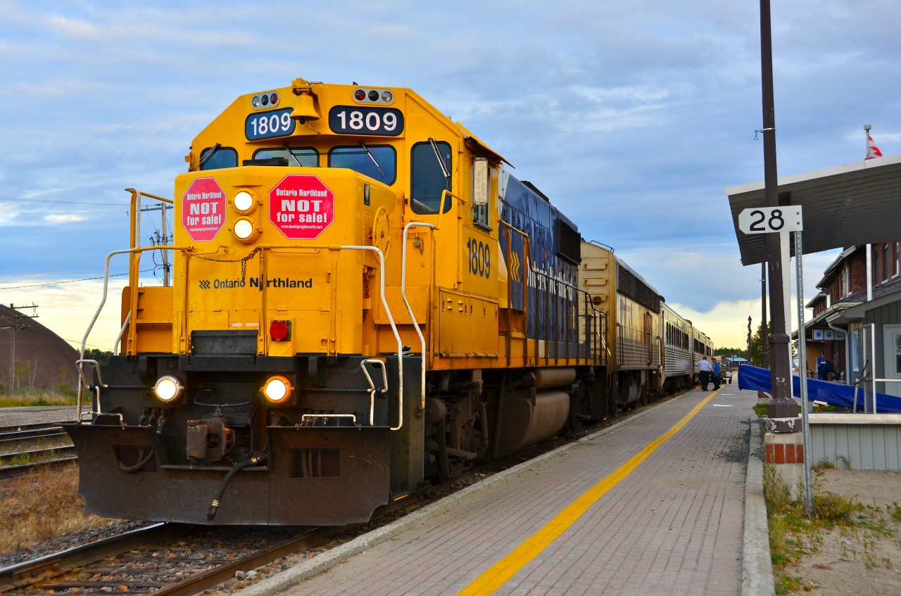 Southbound Northlander (Train 698) at Cochrane, waiting to start its journey. “STOP” signs of protest against the Ontario government's plan to privatize the Ontario Northland were displayed by many homes and businesses in Cochrane, as well as on Ontario Northland structures and equipment.