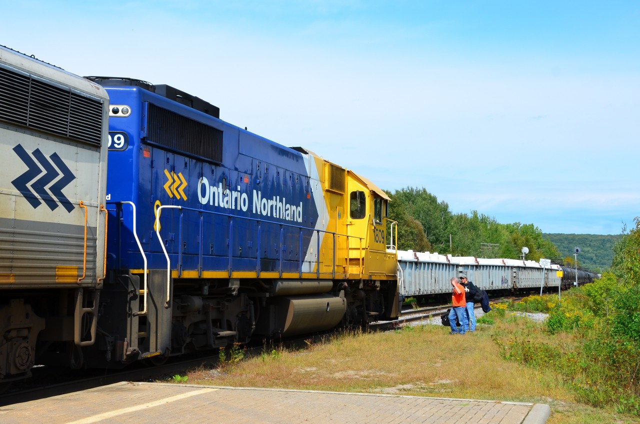 During station stop at North Bay, northbound Northlander changes crew while southbound Ontario Northland freight snakes by