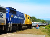 During station stop at North Bay, northbound Northlander changes crew while southbound Ontario Northland freight snakes by