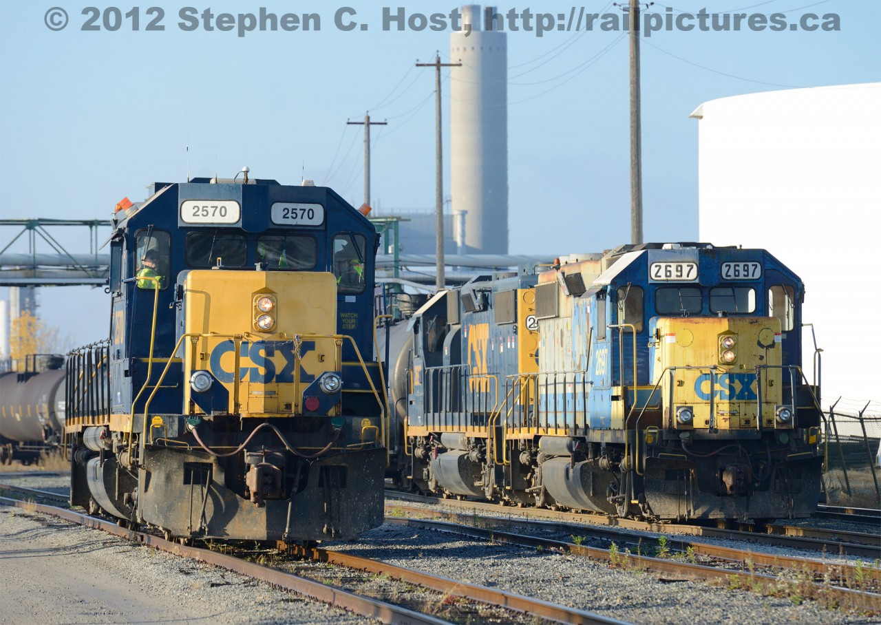 The new and the old - Y120 (right) with CSXT 2697 and 2690 is passing the new Beltpack equipped 2570, with a crew (Consisting of existing CSX Sarnia employees familiar to this Photographer) in training in the cab.  Note the pair of strobes and radio antennae on the cab roof of 2570. Also notice the smaller single strobe on 2697 (which is also on 2570) just above the radiators - anyone have an idea what these may have been installed for? (These are NOT for remote control operations and have never been seen in use)