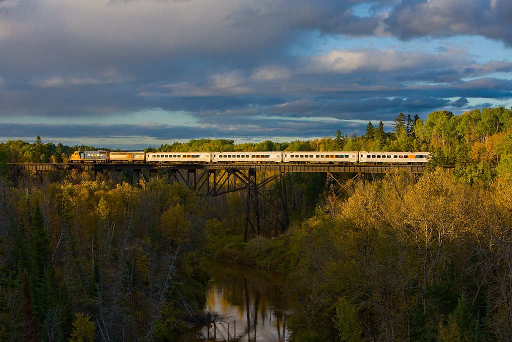 In its last days, the northbound Northlander crosses the large bridge just east of the yard in Englehart.