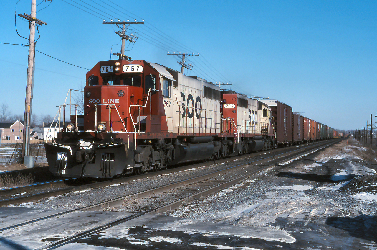 SOO 767 and SOO 765 power a westbound manifest through Beaurepaire on a chill February afternoon