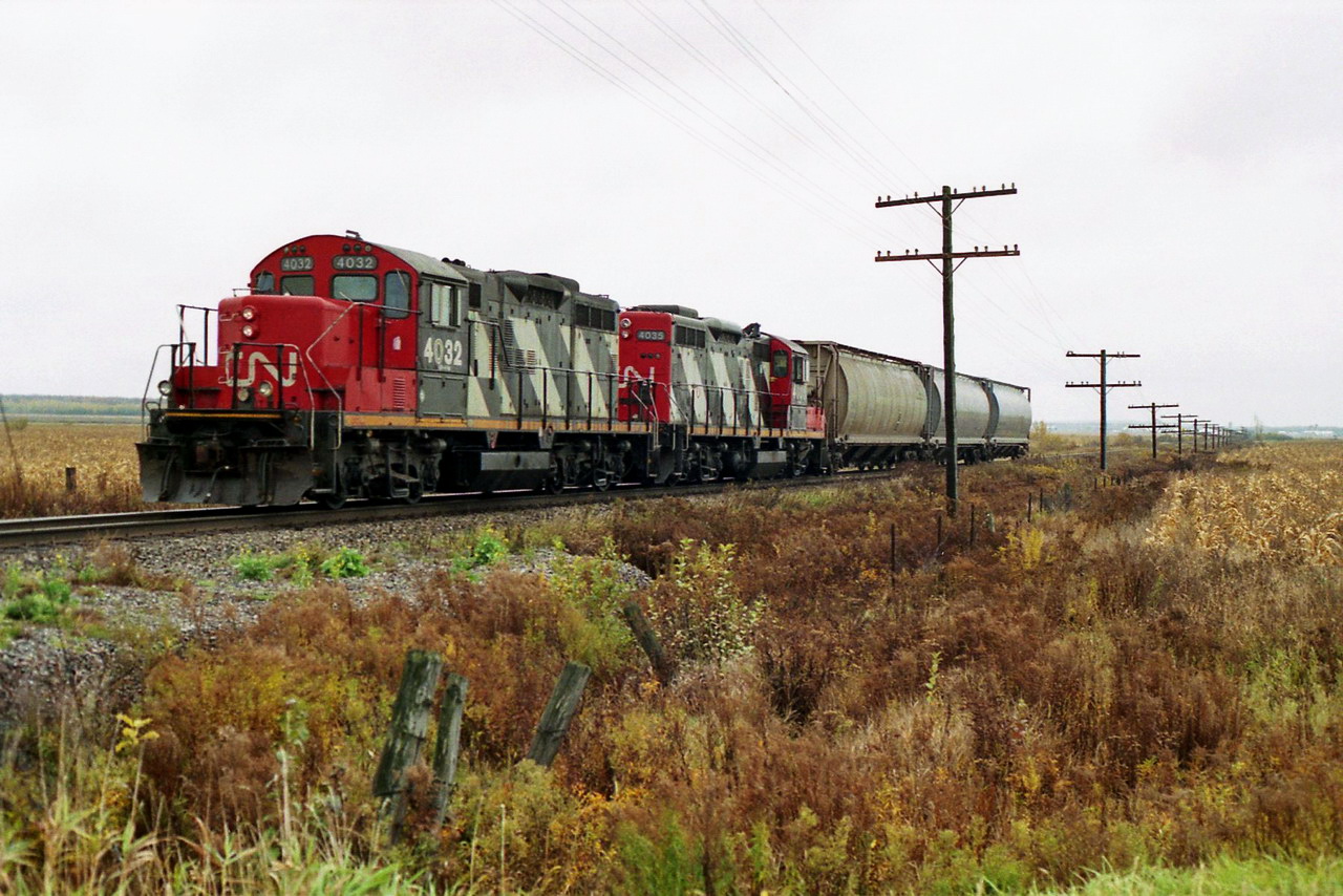 CN 514 is running backward with the brakeman standing well dressed on the last car on this gloomy cool october afternoon.