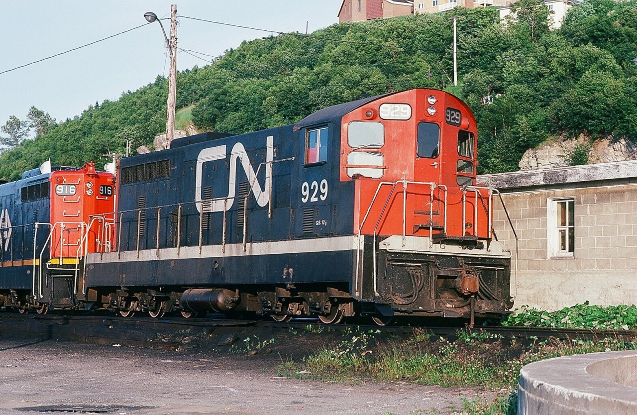 A special place – The Rock. August 2, 1982. Corner Brook, Newfoundland. Idling beside the turntable, Terra Transport NF 210 #929 (in CN paint) and #916 await next assignment. Today 916 and 929 are in Chili. Kodachrome by S. Danko.
