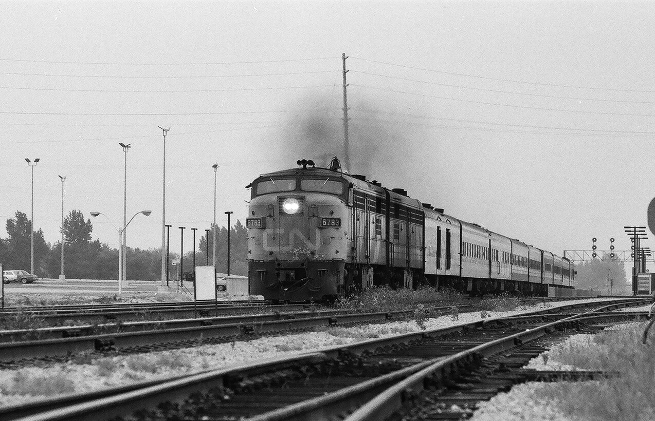 The morning eastbound Rapido, Via CN train #62, with a MLW FPA4/FPB4 pair ( 6783 on the point ) under full power top the hill at Scarborough Junction. 1978 Kodak Plus X negative by S.Danko.