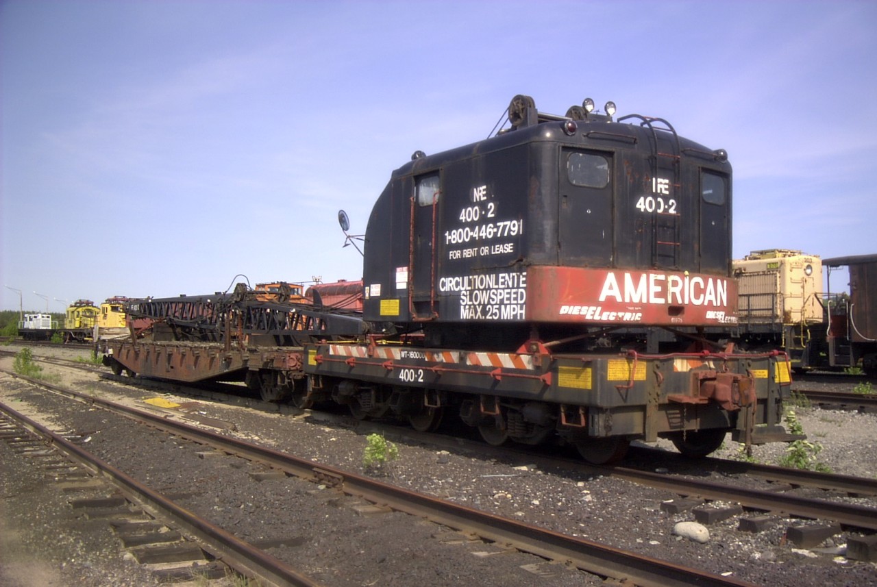 NRE 400-2 ex-CN 30 ton American crane sits quietly at the NRE/ALCO repair shop in Capreol, ON.   It is surrounded by a plethora of motive power and car equipment waiting for repair and/or resale.