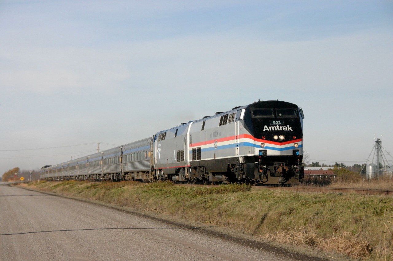 An Extra 694 with a train set leased from VIA Rail for 2 weeks on way to Albany , NY in L'Acadie borough of St-Jean sur Richelieu .