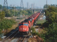 I heard some new power was coming over on CN from Erie. Not knowing just where the train was, I elected to shoot from this location because open areas along Niagara  without shadow are not that easy to find. The offending sumach bush by the mile indicator was not cut because I was afraid the train would come if I wandered down there. Anyway, this train #334 was indeed  a treat, and nowhere else would I have gotten all these units in after 1500 hrs that day. Seen are: CN 5684, 5447, 5269, 2669, 2661, 2670, 2666, 2665, 2662, 2664, 2660, 2667, 2659 and 2663.