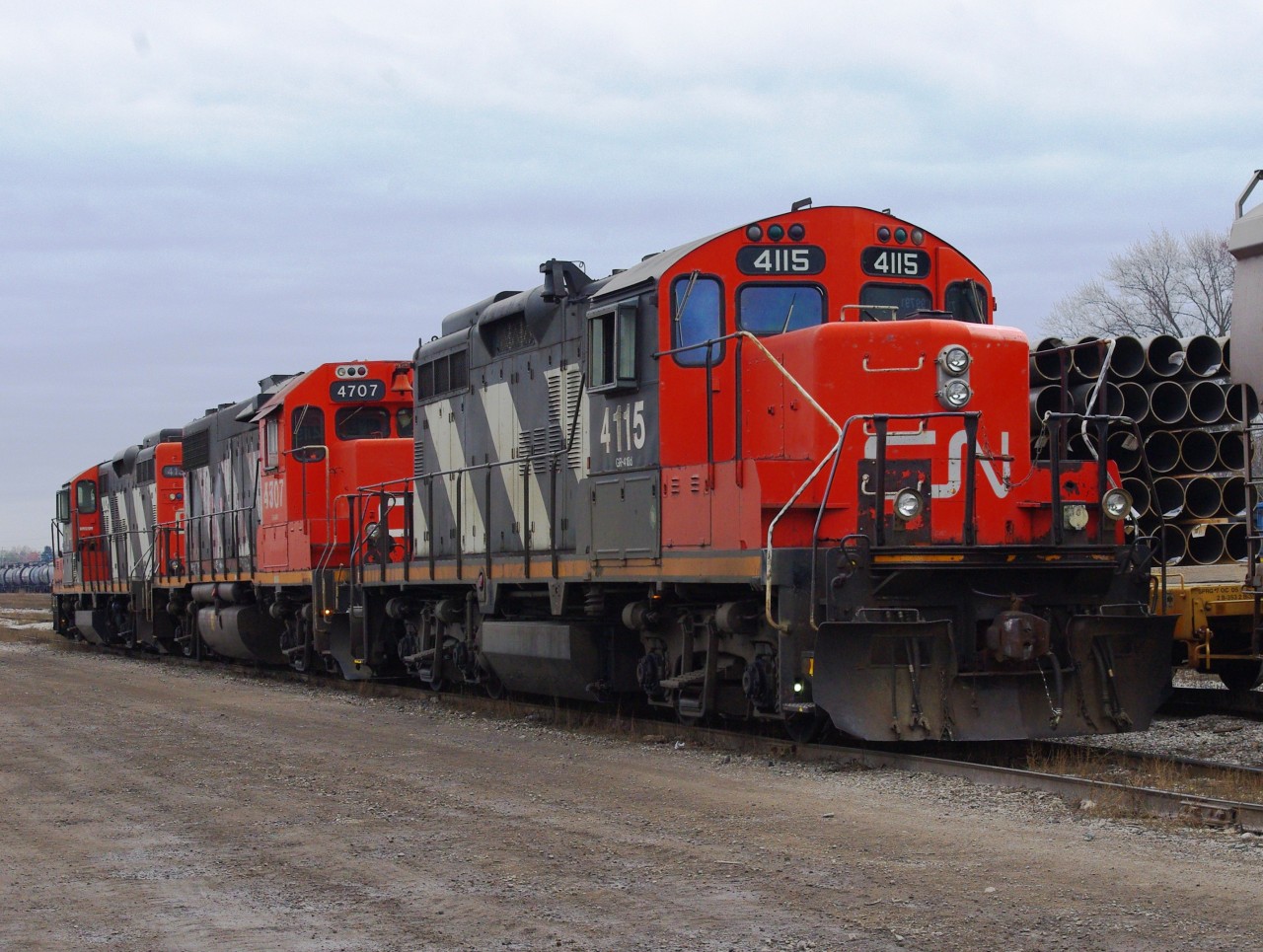 A trio of CN yard grunts sits idling in London's Egerton Street yard waiting for a new crew to get on board. A small maintenance tie gang is changing wood a few tracks over in the middle of several yard tracks so extreme caution is the order of the day with all the yard power and cars moving about.