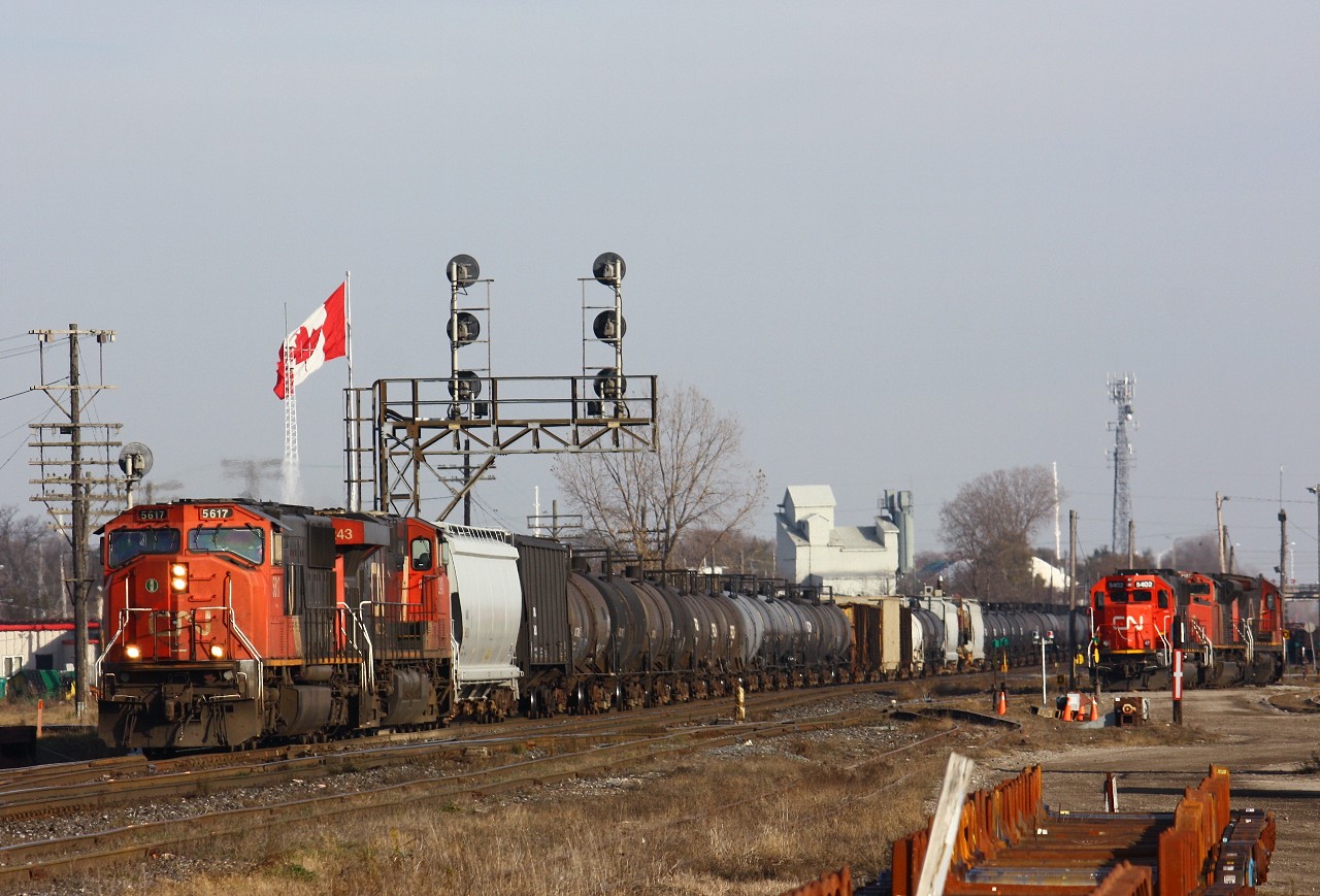 CN 331 rolls through London Jct behind CN 5617-2243. About 25 cars back from the engines was Dofasco #410 riding on a QTTX flatcar riding to NRE Silvis for wreck repairs.