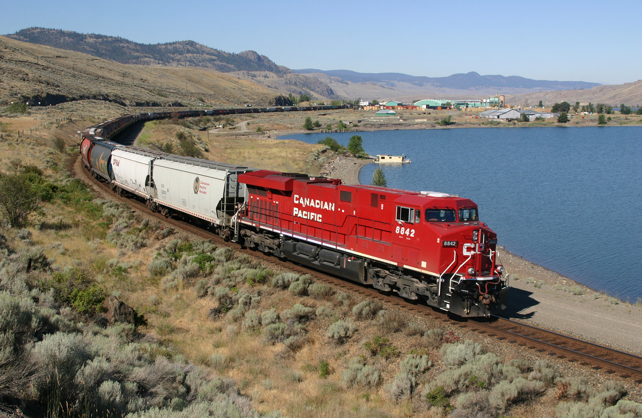 CP 8842 sweeps along side the western end of Lake Kamloops with an empty grain train