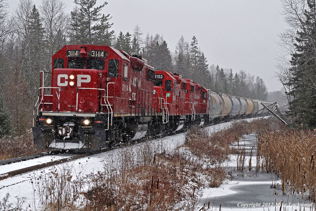 An early snowfall is falling on the moraine as the Kawartha Lakes roadfreight heads east beginning it's decent of Maryanne's Hill. CP 3114, 3103, and 3057 provide the impetus. 1145hrs.