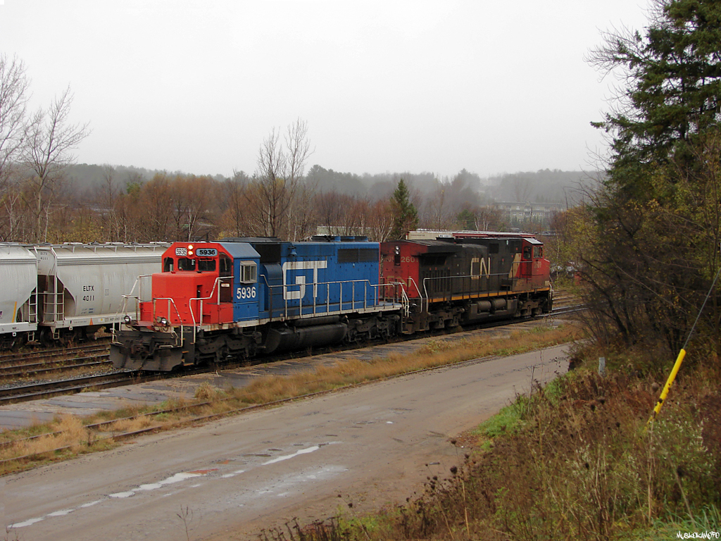 After setting off 1 LRS highcube in track 1, CN A45131 01 is seen returning to their train just South of town during a light rain with GTW 5936 leading on the shove.