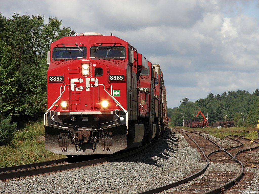CP 110 - CP 8865 South pulls their massive 3+1 setup 122 car train through the dip at South Parry about to knock down a diverging to clear signal back onto home rails the 20 miles to MacTier. A CN crew can be seen loading scrap ties into empty gons in the North end of the yard.