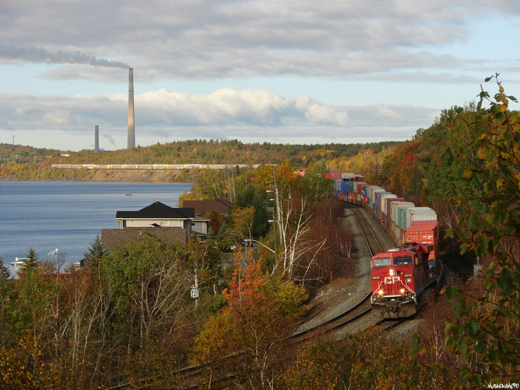 CP 8808 East snakes through the curves along Ramsey lake in the center of Sudbury, robot CP 9739 shoving on the tail end 2 miles of train away.