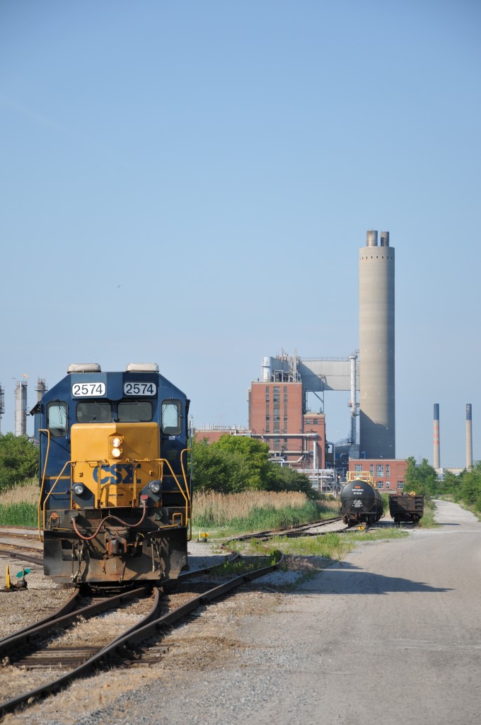 CSX 2574 sits under the impressive stacks of Imperial Oil and the now fallen Dow Chemical Sarnia plant on a sunny June morning.