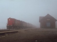 Fog-shrouded morning back on May 14, 1978 as CN's Tempo locomotive #3151 leads an eastbound #70 past the old station at Dundas. This station suffered a stove fire in 1986 which burned thru the roof and put the station permanently out of commission. The town could not come up with the moving/restoration expenses after CN offered them the building for the token $1 charge, and subsequently the building was razed.
