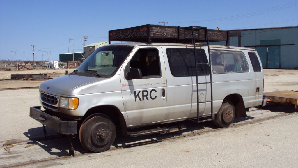 While on a trip to commission a new Knox Kershaw KBR925 ballast regulator for KRC, NAES (Canada) Ltd. Sales Manager David Wylie came across this Keewatin Railway Company Ford van. Certainly not your average hi-rail vehicle found on most railways, this one is steel-wheeled and railbound. The maintenance vehicle is equipped with a turntable allowing the crew to reverse direction of the truck so they do not have to travel backwards for any great distances. Note it is connected to a heavy duty 'push car' for transporting track material and/or small power tools. (Photo by David Wylie used with permission).

The Keewatin Railway Company (KRC) is a First Nations-owned rail line that operates in Northern Manitoba, between The Pas, and Pukatawagan. The railway company owns the line from Sherritt Junction (interchange with Hudson Bay) to Lynn Lake, about 185 miles (310 km). It currently operates mixed (passenger and freight) services from The Pas to Putakawagan, about 156 miles (251 km), of which 58 miles (93 km) is on the tracks of Hudson Bay Railway 

KRC started operations on April 1, 2006. The passenger service, formerly operated by VIA Rail Canada, continues under a new operating agreement between Keewatin Railway Company and Via Rail Canada. KRC operates two round trips between Pukatawagan and The Pas each week. Trains carry passengers and freight for the community of Pukatawagan.