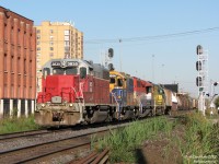 Goderich and Exeter Railway train 431 rumbles through downtown Brampton, with its then-regular rag-tag lashup of second- and third-hand EMD 4-motors in distinctly non-matching paint schemes, about to pound the interlocking diamond a few metres from where the photographer is standing. Today's motley crew consists of GEXR 3835 (GP38), GEXR 3856 (GP38), RLK 4096 (GP40) and GEXR 4046 (GP40), working a good-sized freight courtesy of CN back to home trackage. Today's return train has also "beat the rush", and as a result the CN RTC won't have to juggle a 431 amidst the GO trains beginning half and hour later at 5pm.<br><br>GEXR 431 (from) along with 432 (to) is the daily "Mac-and-Back" train that runs over part of CN's Halton Subdivision to CN's MacMillan Yard for interchanging traffic, resuming regular routing on GEXR's Guelph Sub at Silver (control point west of Georgetown).